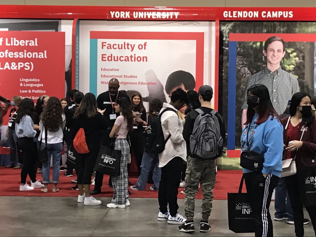 diverse high school students exploring the York University booth at the 2023 Ontario Universities' Fair (OUF)