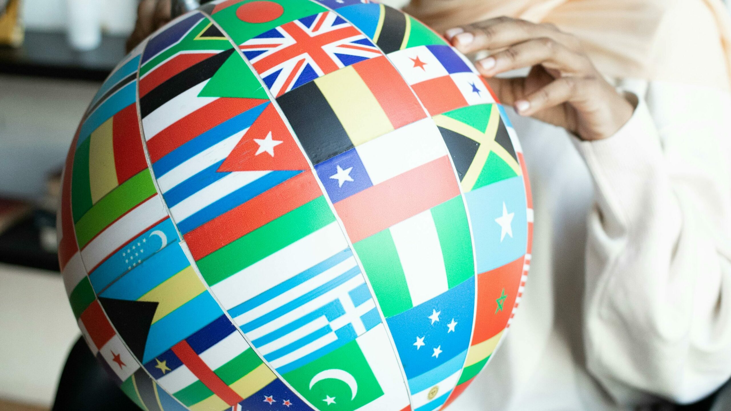 person holding globe with world flags