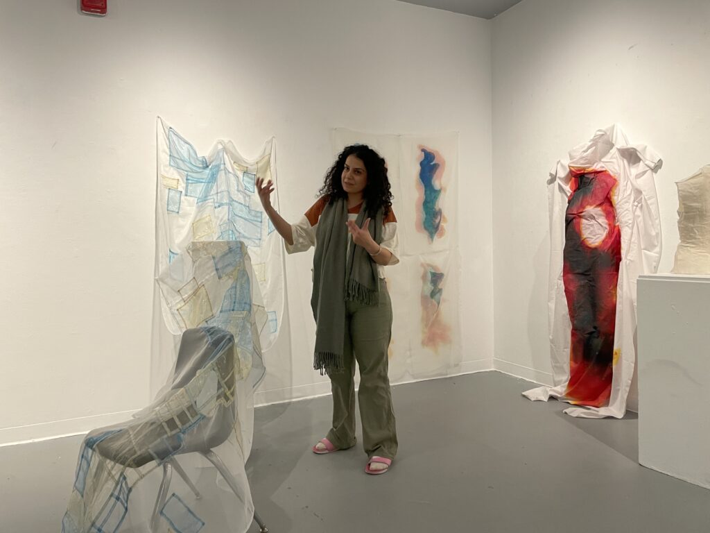 Image of a presenter explaining her artwork to an audience