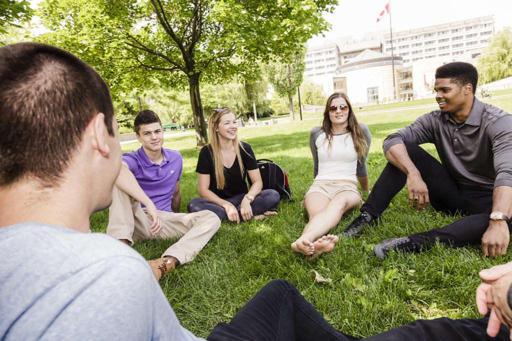 Students sitting on grass with Vari Hall in the background