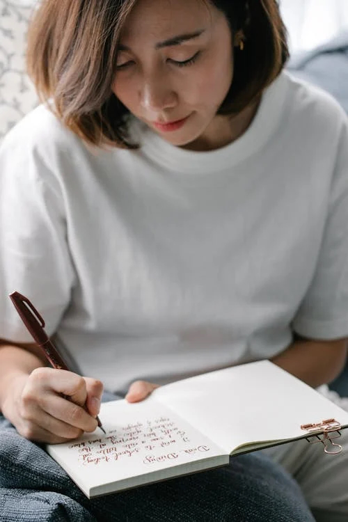a young woman takes notes in a book