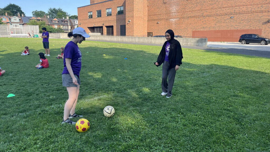 Two students playing soccer