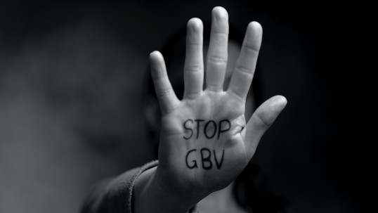 Palm directed towards screen with "STOP GBV" letters written on it