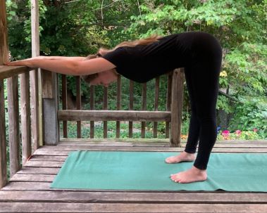 Woman standing in supported downward dog pose