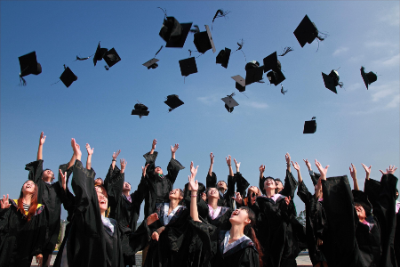 Graduate students throwing their academic cap