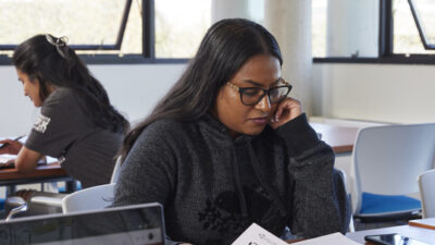 A student reading a textbook in a library