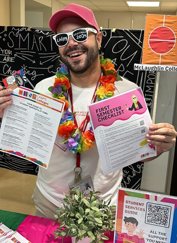 student holding up flyers at a community hub