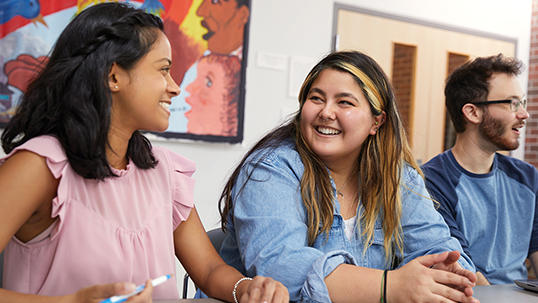 students in a community hub talking and smiling