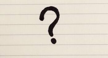 A question mark drawn on lined paper.