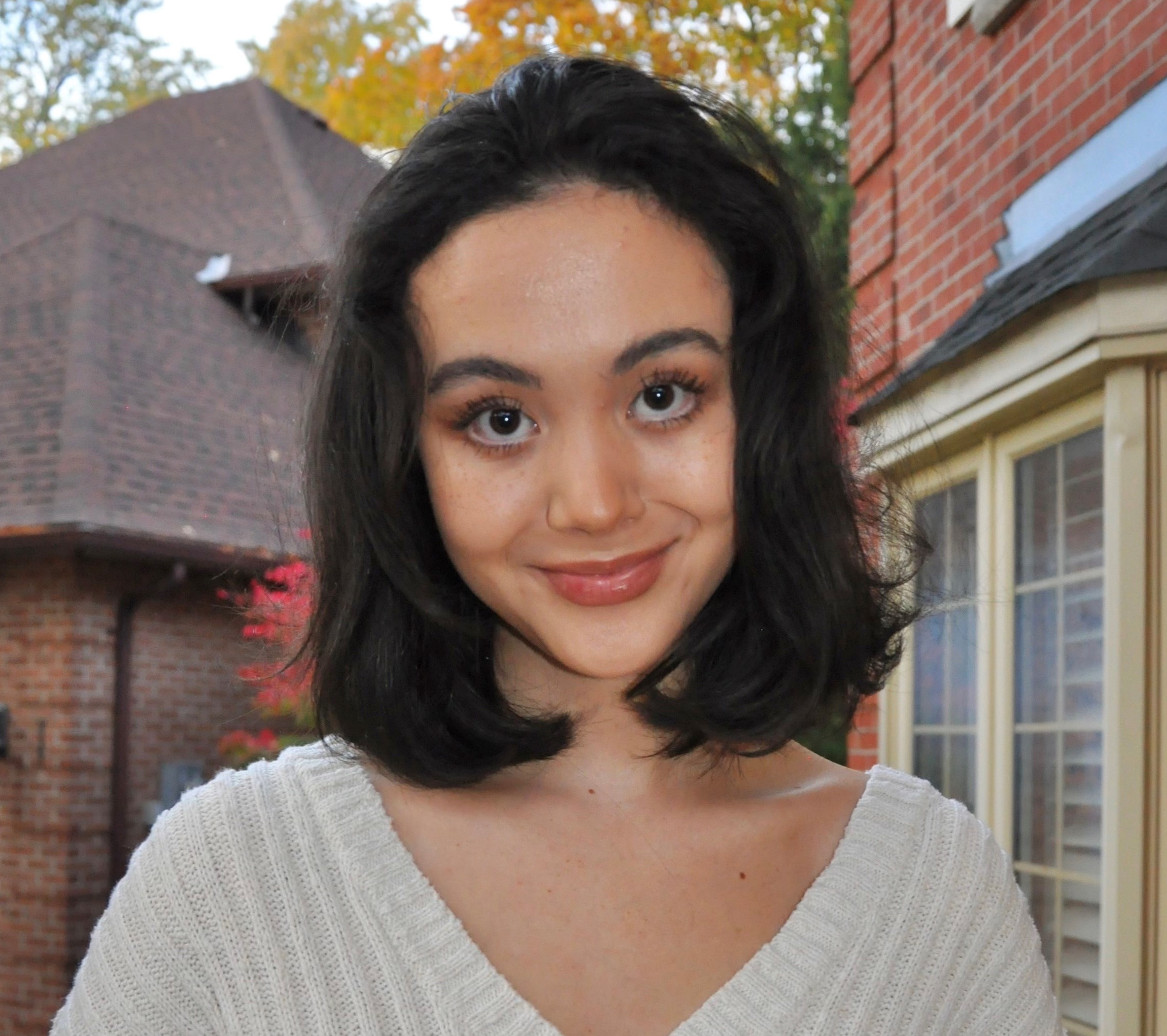 Image of DARE student winner Mckenzie Tzeng-Fearon standing outside in front of a house