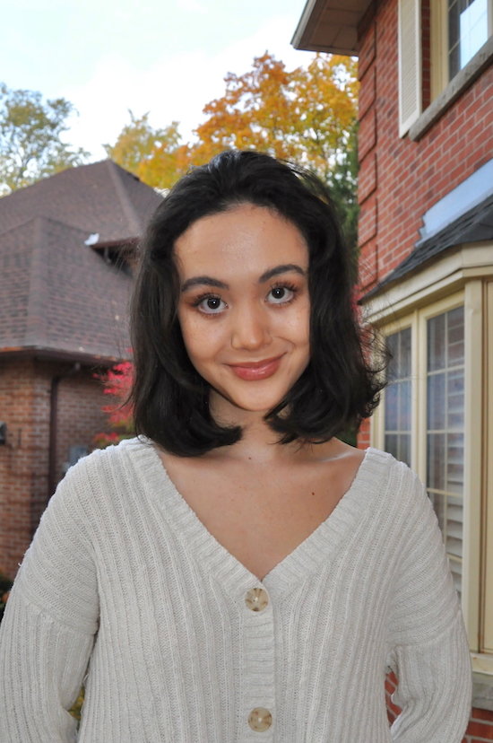 Image of DARE student winner Mckenzie Tzeng-Fearon standing outside in front of a house