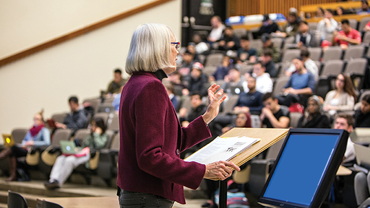 professor teaches large lecture hall of students