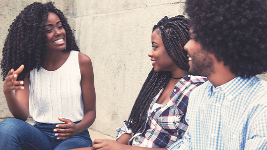 Three black students smiling and talking