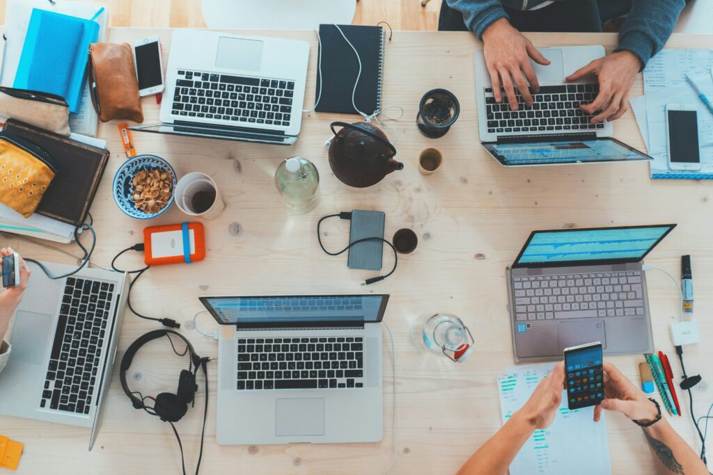 A top-down photo of a cluttered wooden table filled with study equipment Photo: Marvin Meyer on Unsplash.