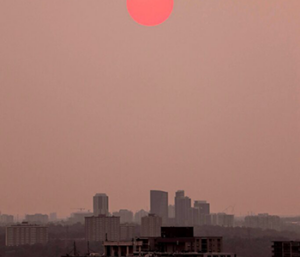 sunset over city skyline on a smoggy day