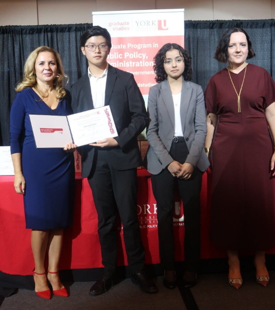 Picture of 1st prize High School Essay Contest winner accepting award on stage