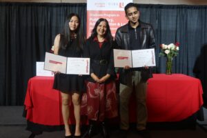 Photo of a High School Teacher and her two students receiving an award on stage