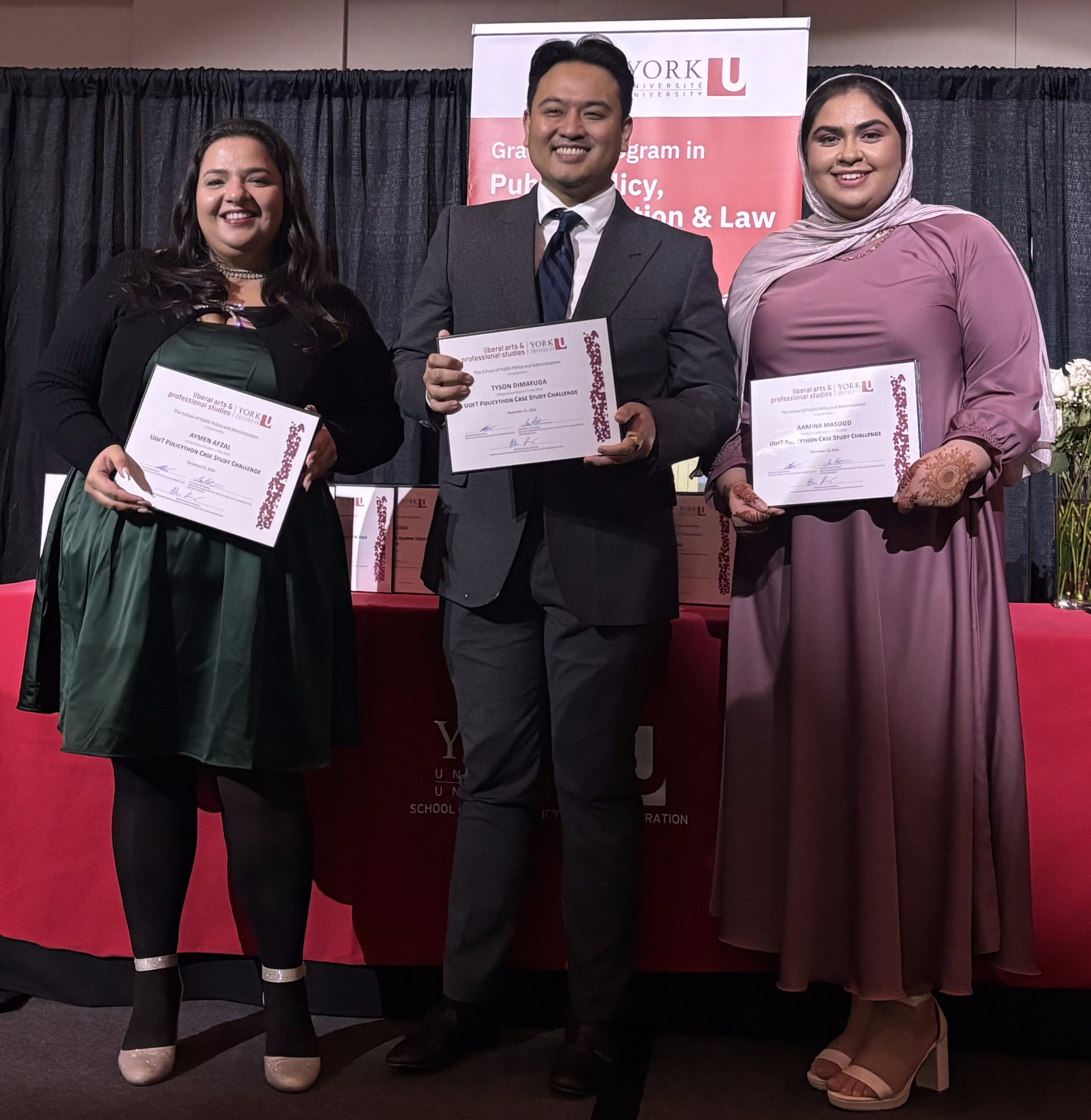 Graduate students on stage receiving awards for participating in the University of Toronto Policython Case challenge.