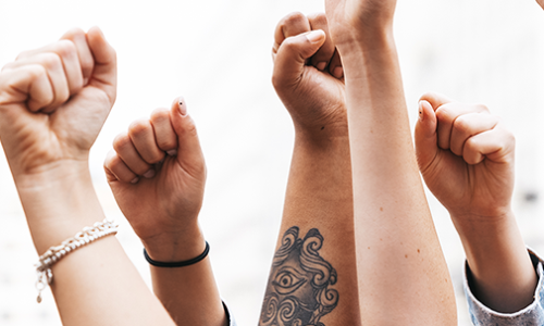 People of different racial backgrounds raising fist in a group