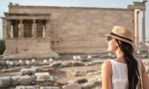 young female student exploring ancient greek ruins