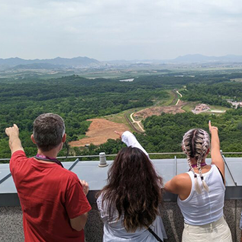 Klassen and students looking out and pointing onto the DMZ and North Korea