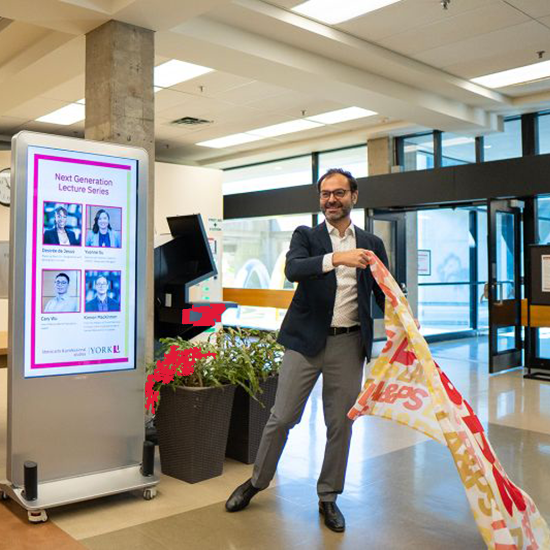 Ravi de Costa pulling the laps flag, revealing a digital kiosk.