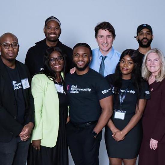 Group of people standing and posing for a photo with Prime Minister Justin Trudeau.