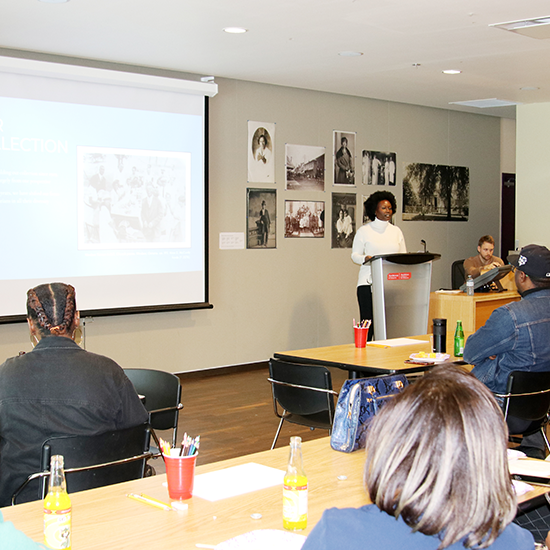 Melissa Nelson standing at the front of the room delivering her presentation.