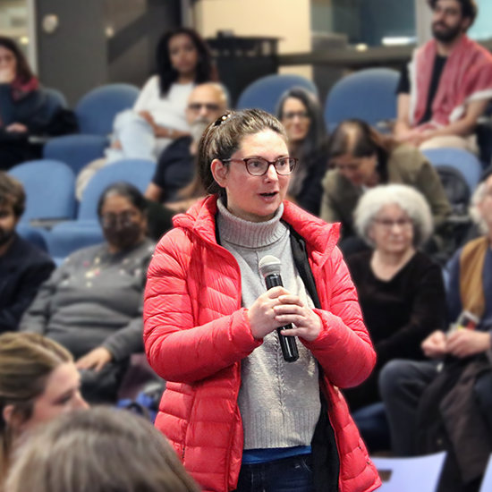 Attendee standing up and asking question into a microphone during Q&A segment.