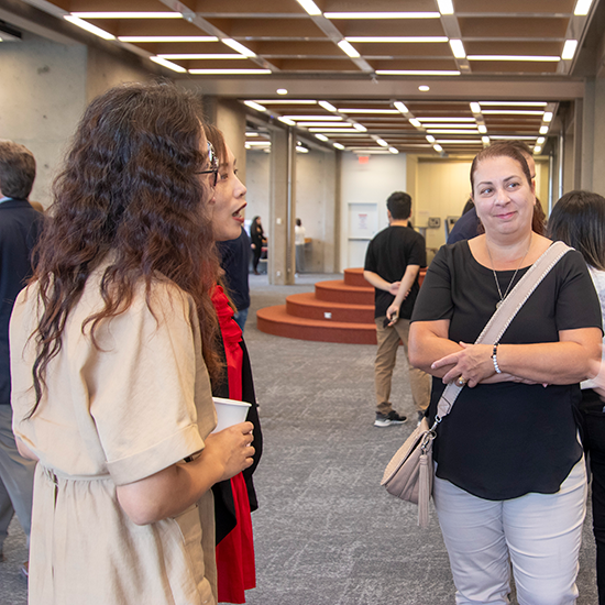 3 people looking at a poster board having a discussion.