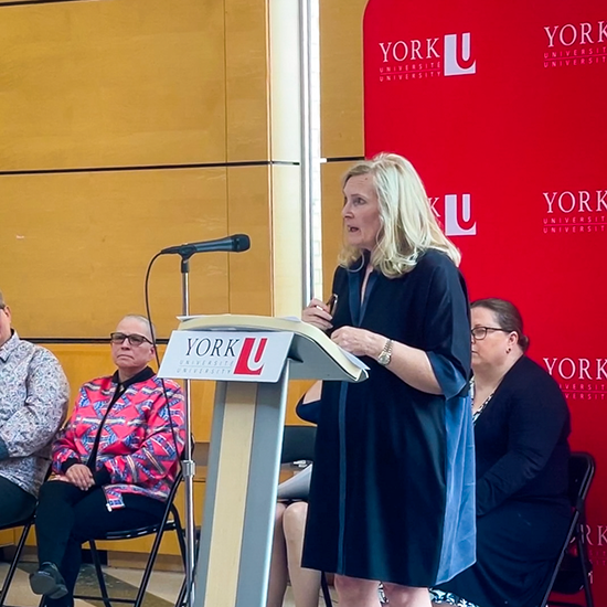 President Rhonda Lenton speaking behind a podium.