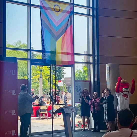 York University community celebrating Pride Month with Flag unveiling in Vari Hall.