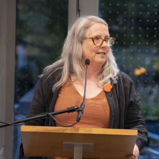 Speaker standing behind a podium delivering her lecture.