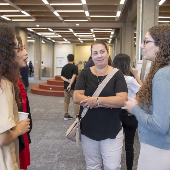 Student discussing her poster project with colleagues.