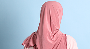 Woman wearing a pink Hijab, facing away from the camera
