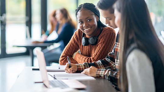 group of students in a classroom in front of laptop