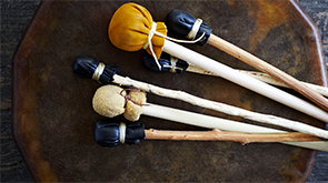 Indigenous drumsticks resting on a drum