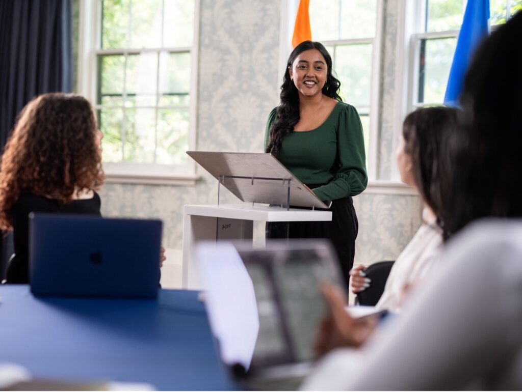 An individual standing at a podium speaking to people