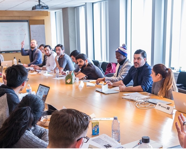 A group of people sitting around a table in an office board room