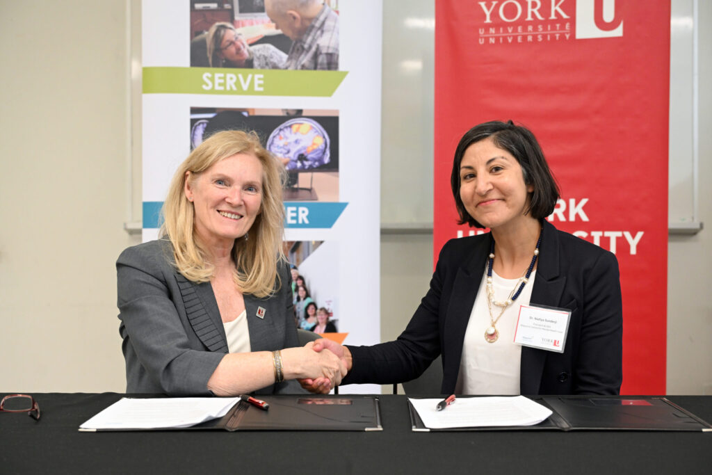 President Rhonda Lenton shaking hands with a partner.