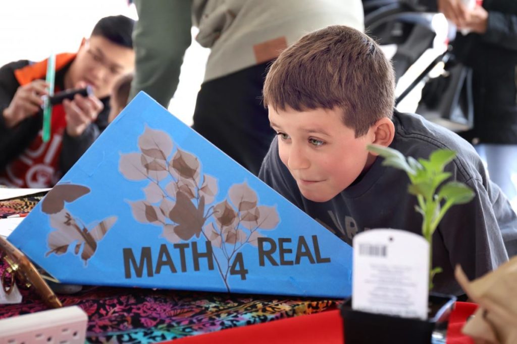 Young student at Math4Real event looking at a diagram