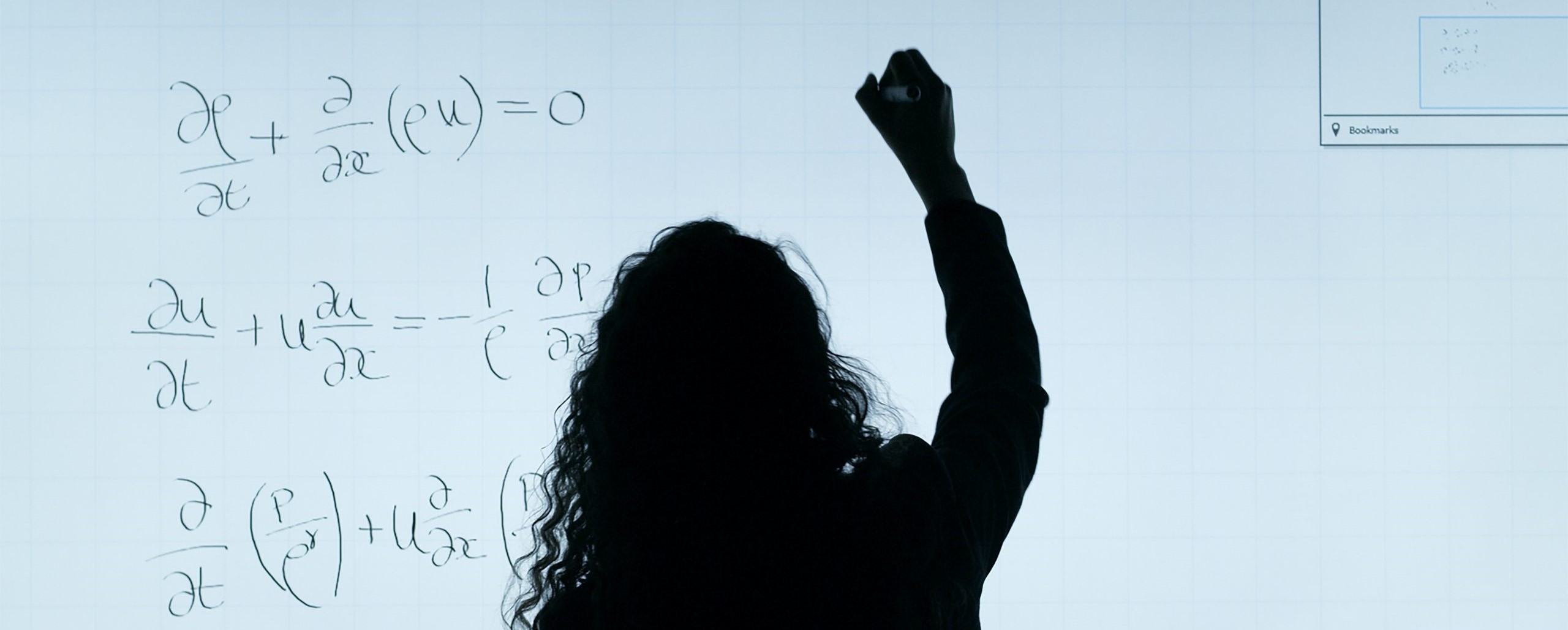 Woman writing math equations on a white board