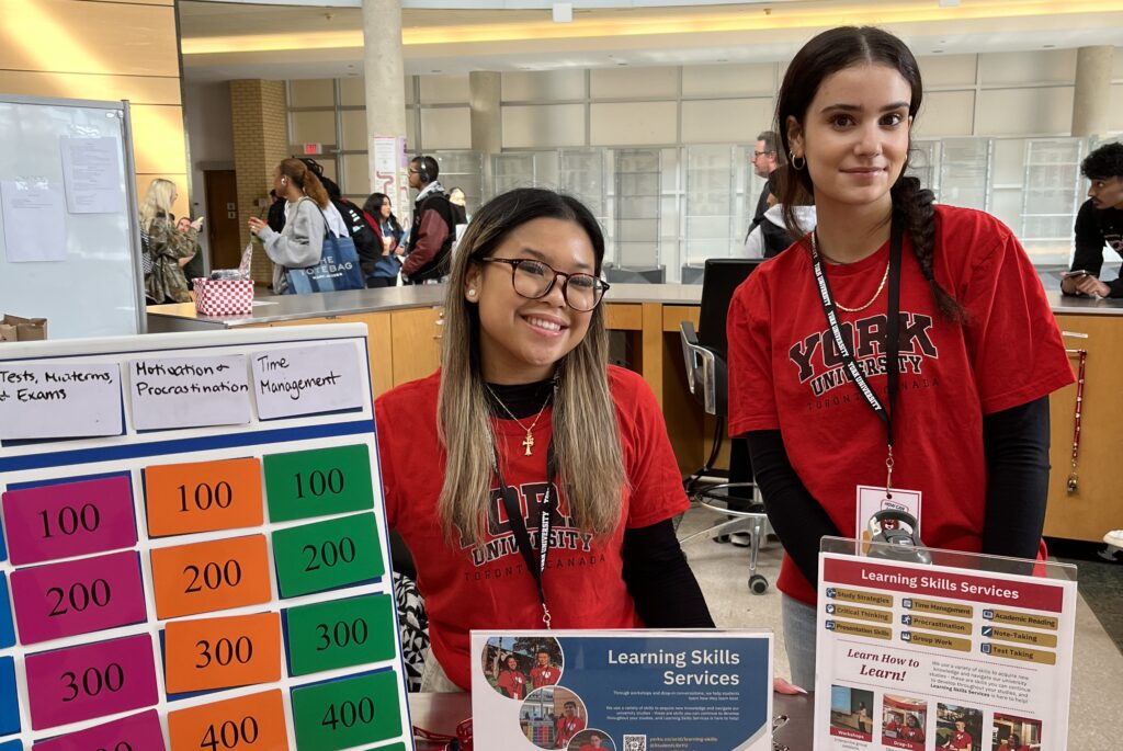 Two Learning Skills Peers smiling at the Vari Hall Kiosk.