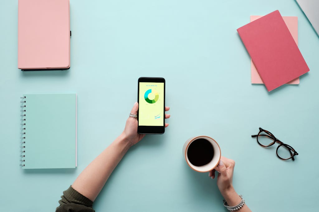 A Person Holding a Smartphone and a Cup of Coffee