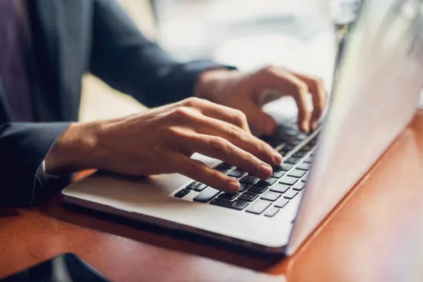 clsoe up of a man working on a laptop 