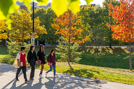 Students walk by campus buildings in Fall