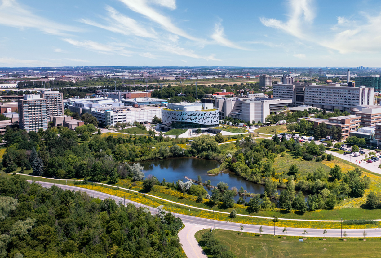 An aerial photo of the York University campus, with lots of green space and a pond. 