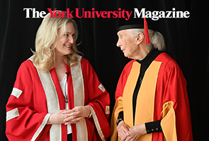 Jane Goodall and President Lenton look at each other while wearing grad regalia. 