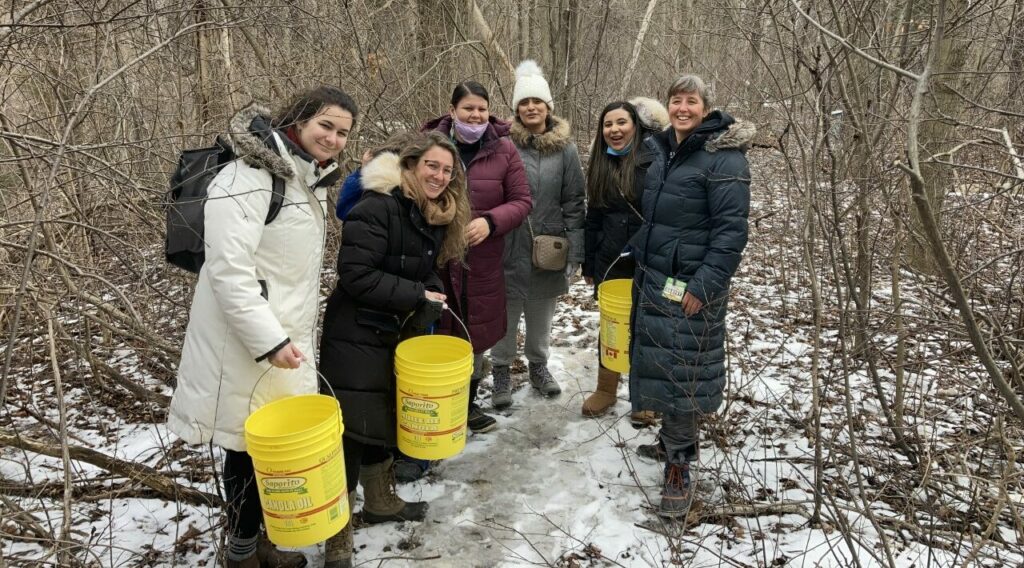 Graduate students, professor and members of SweetGrass Roots Collective gathering sweet water at Black Creek Community Farm. L-R: Olivia, Jessica, Star, Kashfa, Sana and Jennifer