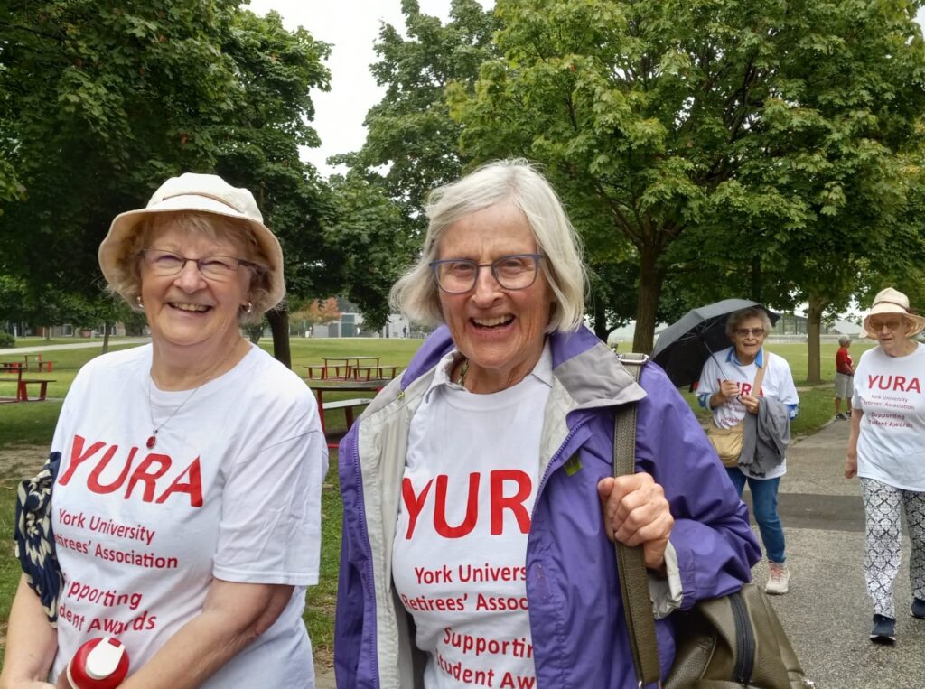 Close up of Diane Woody and Gwyn Buck walking by the University Common